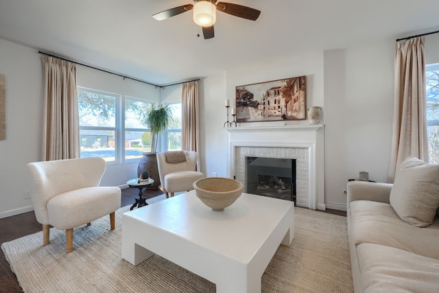 living room with ceiling fan, a fireplace, and baseboards