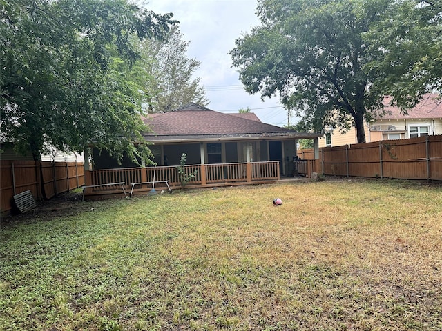 rear view of house featuring a fenced backyard and a yard