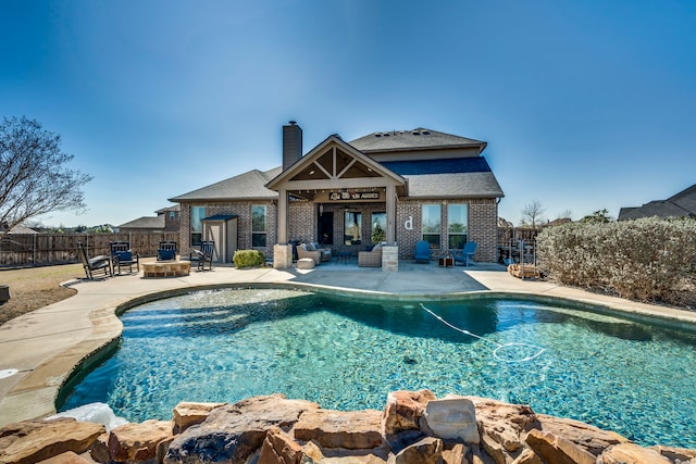 view of pool with a fire pit, a patio area, and fence