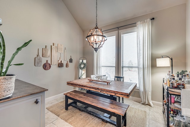 dining space with vaulted ceiling, light tile patterned floors, a chandelier, and baseboards