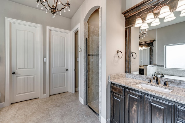 bathroom with a chandelier, a stall shower, and vanity