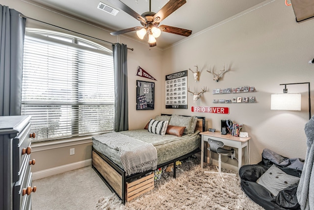 bedroom with light carpet, baseboards, visible vents, ceiling fan, and ornamental molding