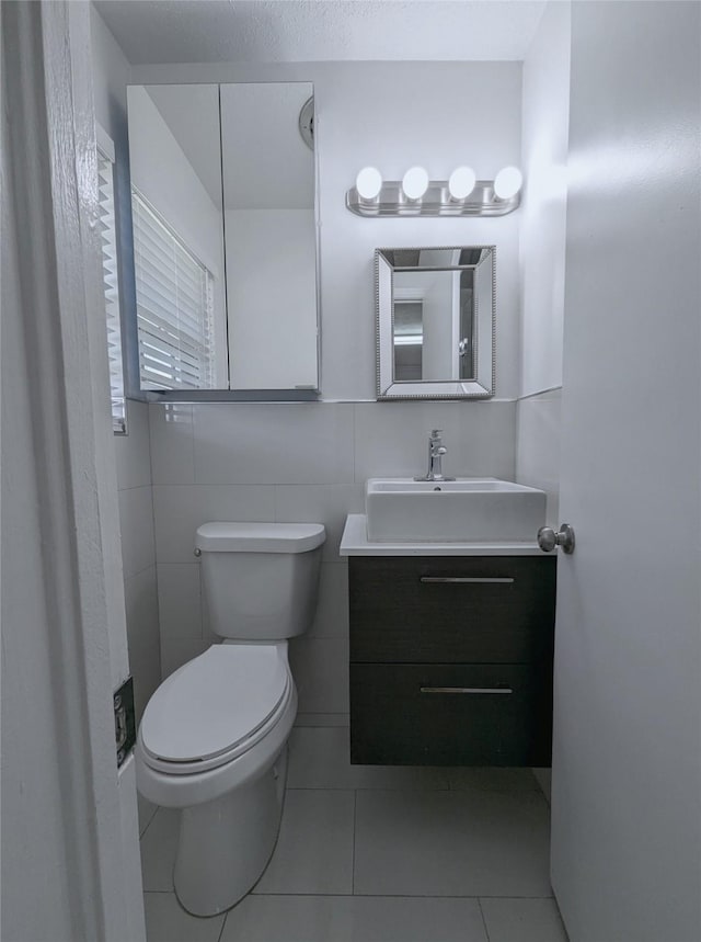 half bathroom featuring vanity, toilet, and tile patterned floors