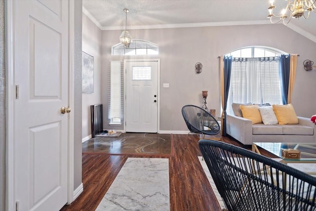 foyer entrance featuring ornamental molding, dark wood-style flooring, an inviting chandelier, and baseboards