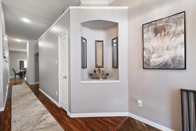 corridor with dark wood-type flooring and baseboards