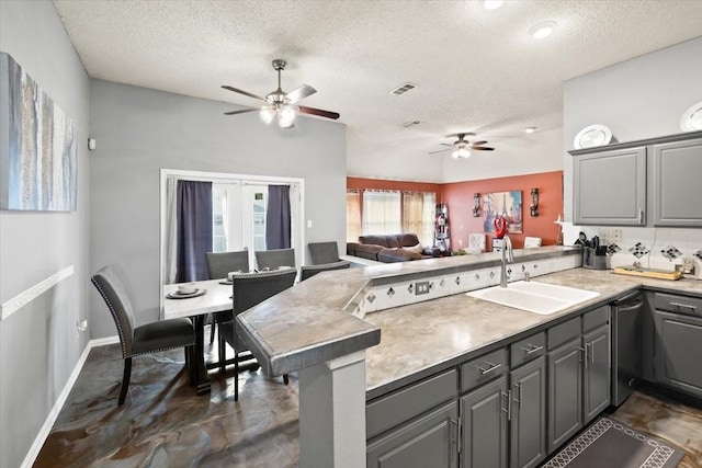 kitchen with a peninsula, gray cabinets, a sink, and open floor plan