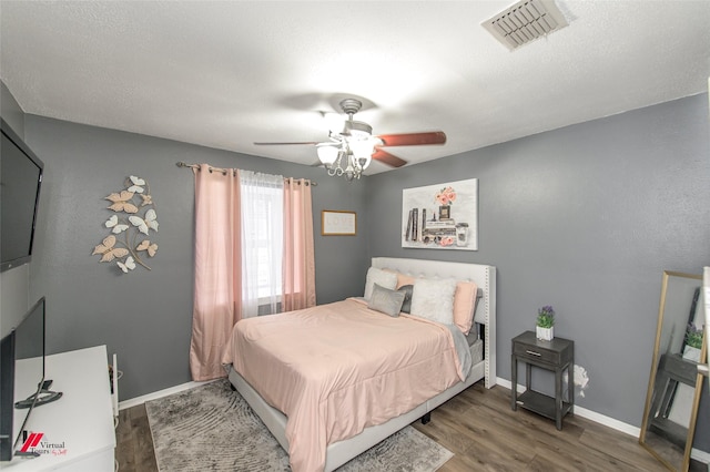 bedroom with dark wood-style floors, baseboards, visible vents, and a ceiling fan