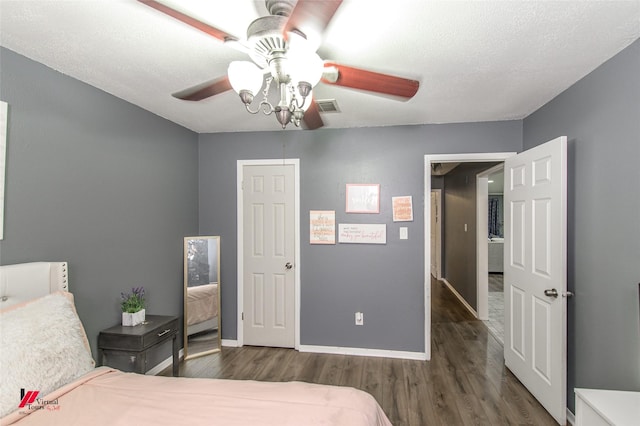 bedroom featuring dark wood-style flooring, visible vents, ceiling fan, and baseboards