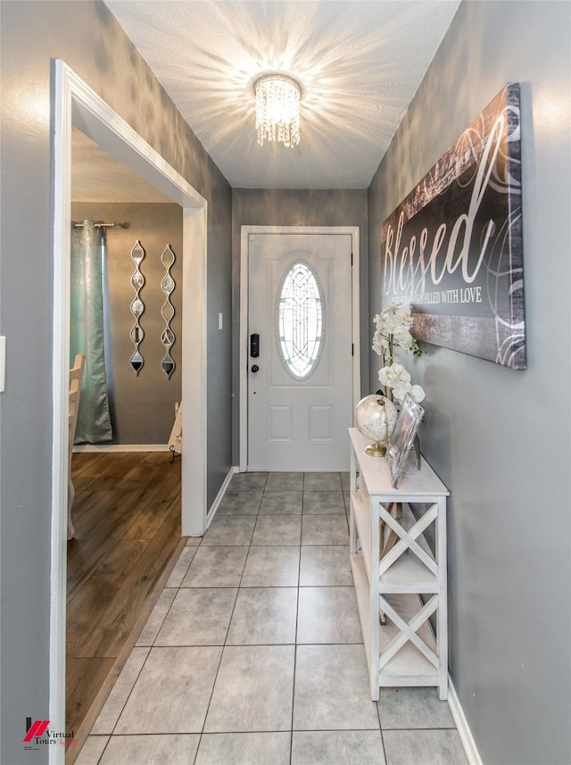 tiled entrance foyer featuring baseboards