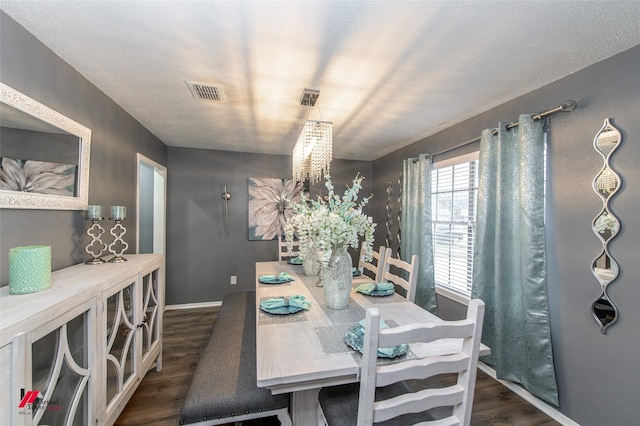 dining area with dark wood-type flooring, visible vents, and baseboards