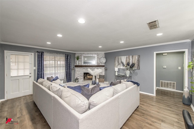 living area featuring ornamental molding, wood finished floors, and visible vents