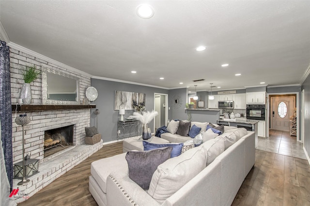 living area with recessed lighting, a brick fireplace, wood finished floors, and crown molding