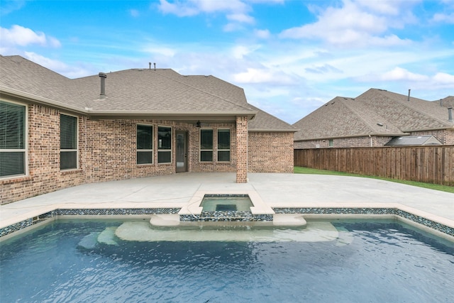 view of pool with a patio area, a pool with connected hot tub, and fence