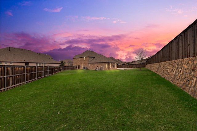 yard at dusk with a fenced backyard