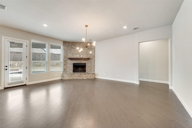 unfurnished living room featuring baseboards, visible vents, a chandelier, and dark wood-type flooring