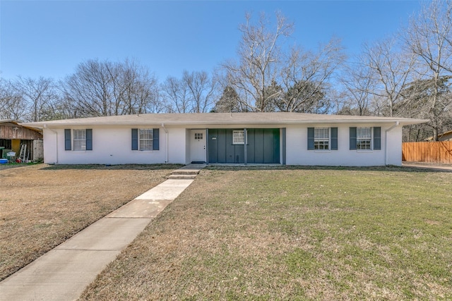 single story home featuring board and batten siding, fence, and a front lawn