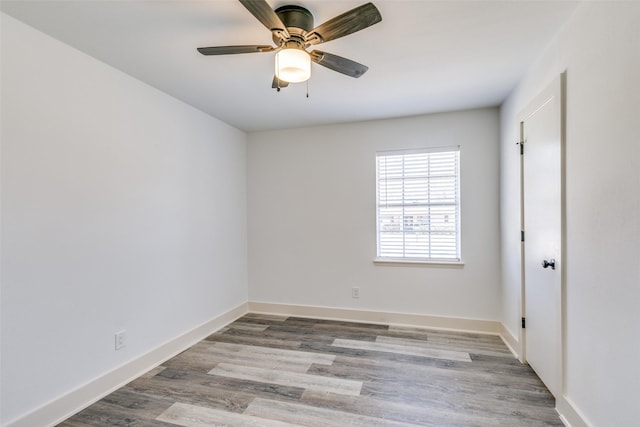 spare room featuring baseboards, ceiling fan, and light wood finished floors