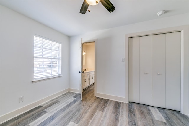 bedroom featuring light wood-style floors, a closet, baseboards, and a ceiling fan