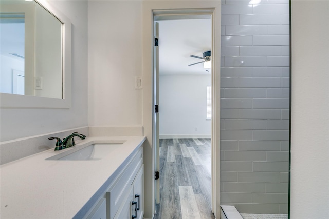 bathroom featuring a ceiling fan, vanity, baseboards, and wood finished floors