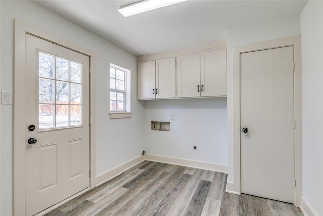 clothes washing area featuring hookup for a washing machine, cabinet space, light wood-style flooring, hookup for an electric dryer, and baseboards