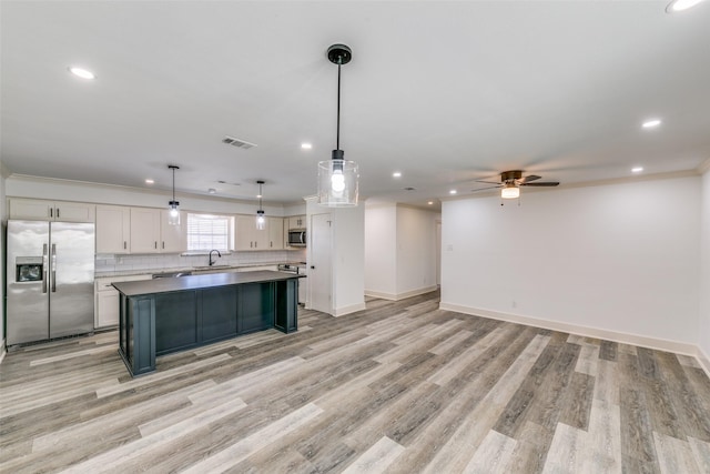 kitchen featuring visible vents, white cabinets, appliances with stainless steel finishes, a center island, and pendant lighting