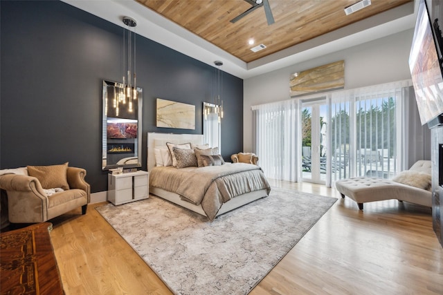 bedroom featuring visible vents, wooden ceiling, wood finished floors, access to outside, and a fireplace