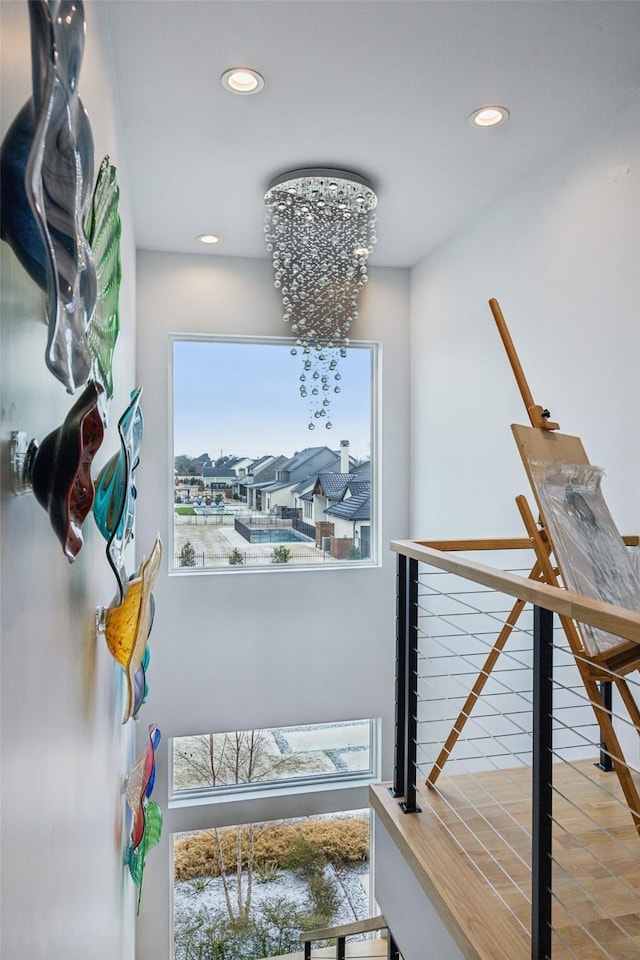 hallway with an inviting chandelier, a residential view, and recessed lighting