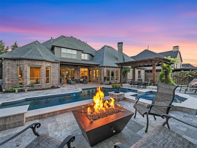 exterior space with brick siding, a patio, fence, a pergola, and a fire pit