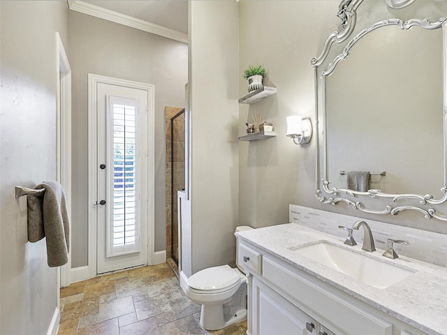 bathroom featuring stone tile floors, toilet, ornamental molding, vanity, and baseboards