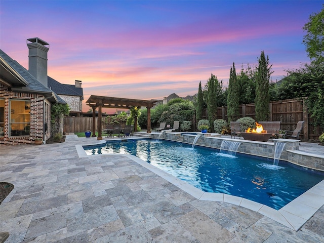 pool at dusk featuring a fire pit, a fenced backyard, a patio area, a pool with connected hot tub, and a pergola