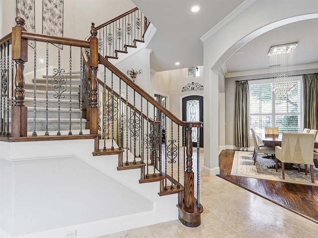 entryway featuring recessed lighting, baseboards, arched walkways, and ornamental molding