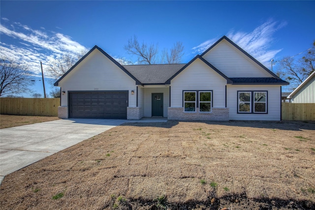 view of front of home featuring a garage, concrete driveway, brick siding, and fence