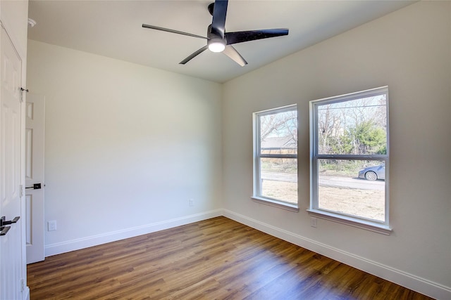 spare room featuring a ceiling fan, baseboards, and wood finished floors