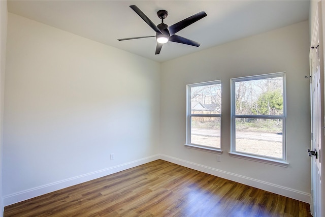 empty room featuring ceiling fan, wood finished floors, and baseboards