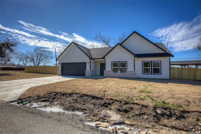 view of front facade with brick siding, concrete driveway, fence, a garage, and a front lawn