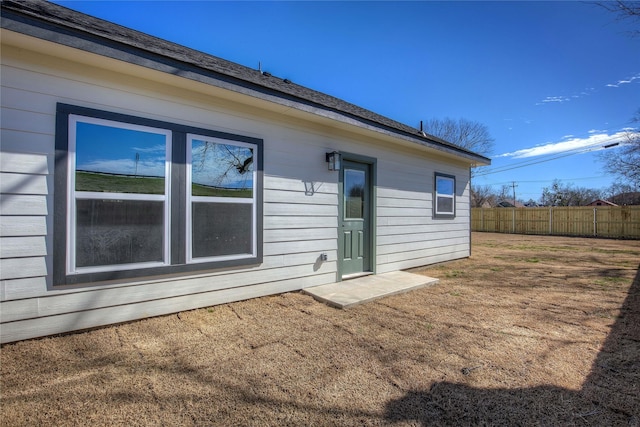 rear view of property with a yard and fence