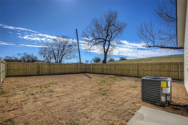 view of yard with central AC and a fenced backyard