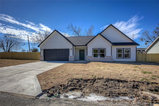 view of front of home featuring a garage, fence, concrete driveway, and brick siding