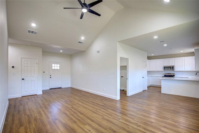 unfurnished living room featuring high vaulted ceiling, wood finished floors, visible vents, and a ceiling fan