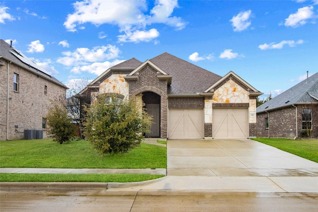 french provincial home with driveway, a shingled roof, stone siding, a front lawn, and brick siding