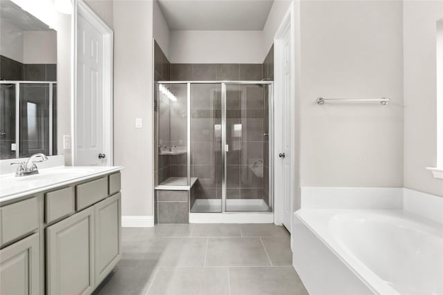 full bath with a stall shower, a garden tub, vanity, and tile patterned floors