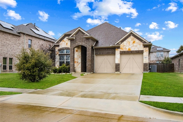 french provincial home with driveway, a shingled roof, a front yard, and brick siding