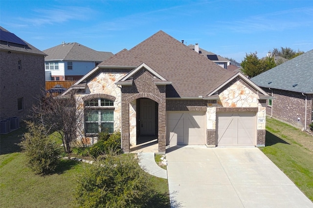 french provincial home with a garage, driveway, roof with shingles, a front lawn, and brick siding