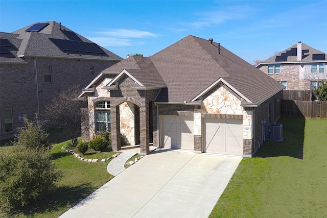 french provincial home featuring a garage, brick siding, fence, concrete driveway, and a front lawn