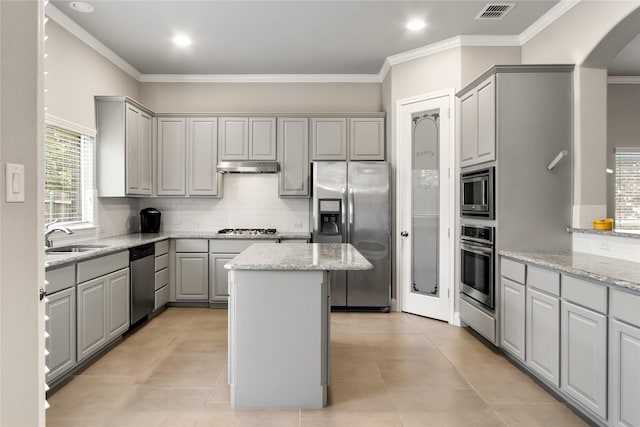 kitchen with a center island, visible vents, gray cabinetry, appliances with stainless steel finishes, and under cabinet range hood