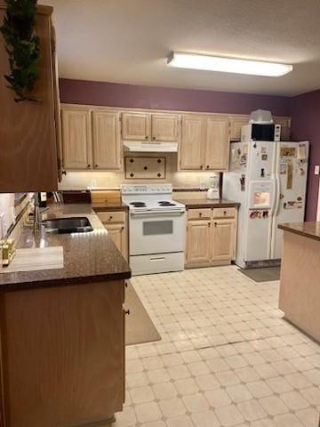 kitchen with light floors, light brown cabinets, a sink, white appliances, and under cabinet range hood