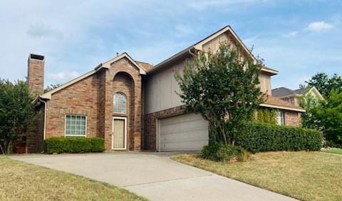 view of front of property featuring brick siding, a chimney, a front yard, a garage, and driveway