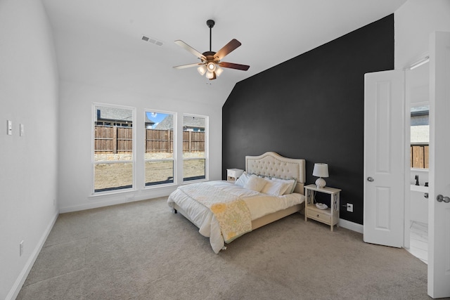 bedroom with vaulted ceiling, baseboards, visible vents, and light colored carpet