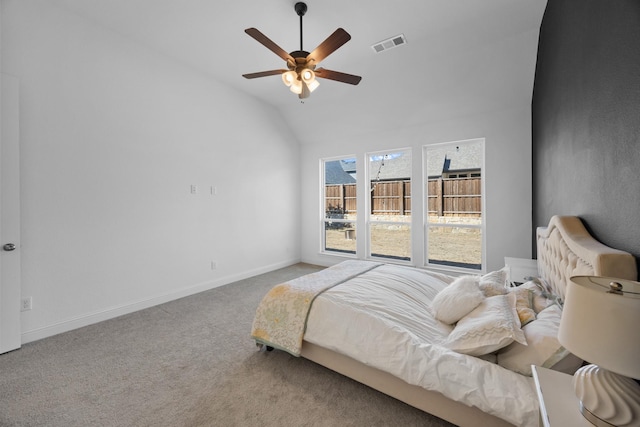 carpeted bedroom featuring lofted ceiling, a ceiling fan, visible vents, and baseboards