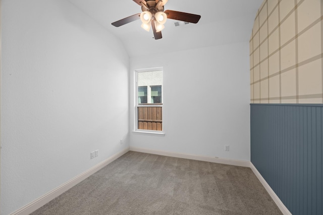 carpeted empty room with a ceiling fan, lofted ceiling, and baseboards